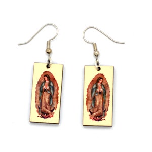 These rectangle earrings feature an image of the iconic Virgin of Guadalupe. The image is reversed on the two earrings so they can face each other or look away from each other. The background is beige.