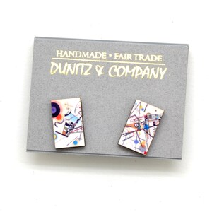 This shows our earrings on a grey earring card featuring our Dunitz & Company logo in metallic gold with the words handmade and fair trade.