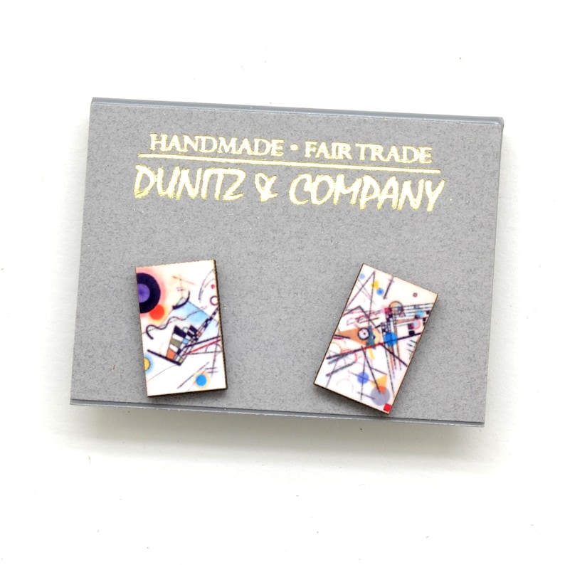 This shows our earrings on a grey earring card featuring our Dunitz & Company logo in metallic gold with the words handmade and fair trade.