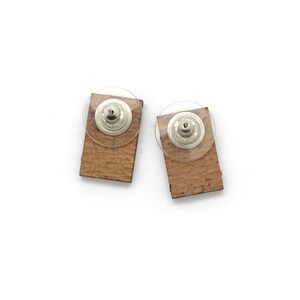 The backside of these laser cut earrings show the recycled pressed wood board. The color is brown.