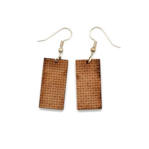 The backside of these laser cut earrings show the recycled pressed wood board. The color is brown.