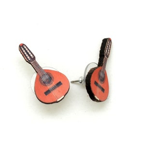 May include: A pair of stud earrings featuring a red and black guitar design. The guitar is a mandolin with a rounded body and a long neck.