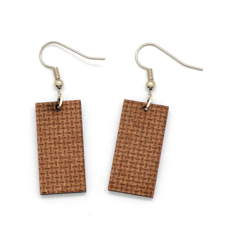 The backside of these laser cut earrings show the recycled pressed wood board. The color is brown.