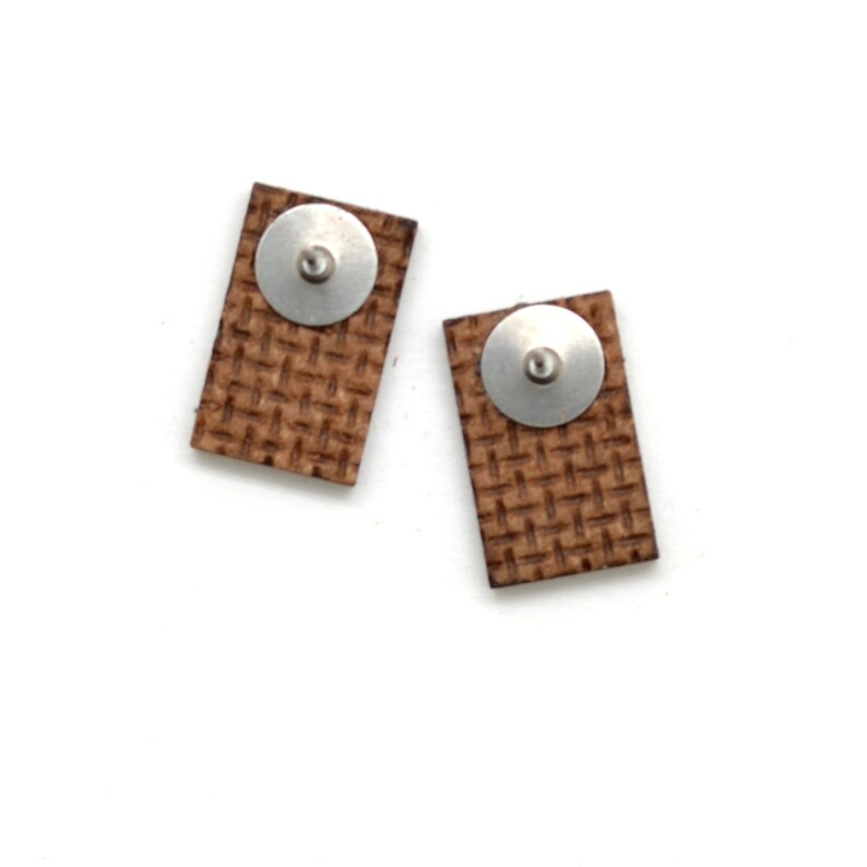 The backside of these laser cut earrings show the recycled pressed wood board. The color is brown.