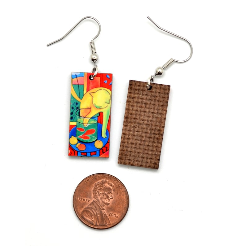 Famous art earrings shown with a USA penny. The penny is wider than the earrings.