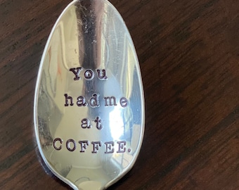 May include: A silver spoon with the phrase "You had me at coffee." engraved on the bowl.
