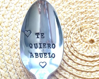 May include: A silver spoon with the words "Te Quiero Abuelo" and two hearts engraved on the front.