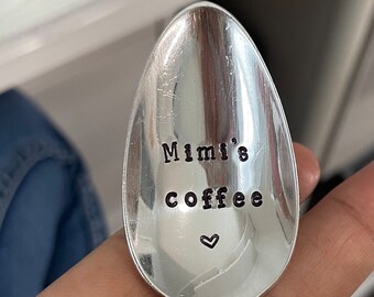May include: A silver spoon with the words "Mimi's coffee" engraved on it, with a small heart symbol below the text.
