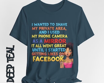 May include: Deep teal t-shirt with a humorous graphic. The text reads, "I WANTED TO SHAVE MY PRIVATE AREA, AND I USED MY PHONE CAMERA AS A MIRROR. IT ALL WENT GREAT UNTIL I STARTED GETTING LIKES ON FACEBOOK." A cartoon woman is also featured.