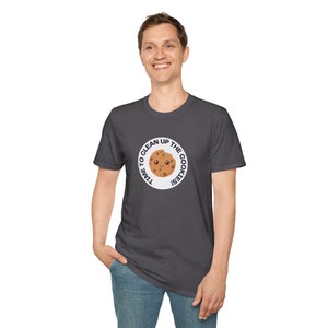 Könnte beinhalten: Dunkelgraues T-Shirt mit einem kreisförmigen Aufdruck, der einen lächelnden Cartoon-Keks zeigt. Der Text "TIME TO CLEAN UP THE COOKIES!" ist um den Keks herum gedruckt. Das T-Shirt hat einen Rundhalsausschnitt.
