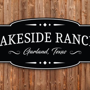 May include: A black and white sign with the text "LAKESIDE RANCH Garland, Texas" on a wooden background. The sign has a decorative border and embellishments.