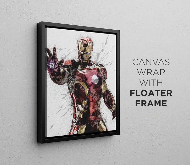 Op de afbeelding: Een zwart ingelijste canvasprint van een superheld in een rood en gouden pak met een witte achtergrond. De superheld staat met zijn arm uitgestrekt en heeft een vastberaden uitdrukking op zijn gezicht. De tekst "CANVAS WRAP WITH FLOATER FRAME" is zichtbaar in de rechterbenedenhoek van de afbeelding.