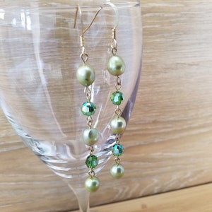 Peut inclure: Une paire de boucles d'oreilles longues et pendantes avec une chaîne dorée et des perles vertes et des perles de cristal vertes alternées.