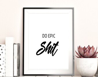 Puede incluir: Impresión artística enmarcada en negro con las palabras "DO EPIC Shit" en fuente negra. La impresión se muestra sobre una superficie blanca, junto a una pila de libros y una suculenta en maceta. La estética general es moderna y minimalista.