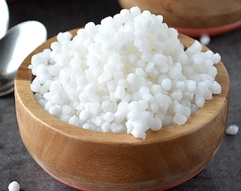 May include: A wooden bowl filled with white tapioca pearls. The bowl is on a gray surface.