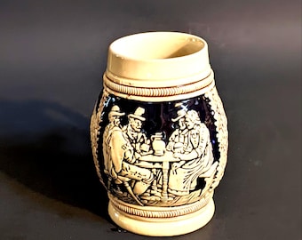 Jarra de cerveza alemana de 11,7 cm (4-5/8"). Escenas de taberna y chalet/molino, fondo azul cobalto. N.° de inventario 0726C