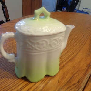 Dainty 4-1/4&quot; Porcelaim Creamer. White-to-Light Green Glaze. Unmarked Except For &quot;II&quot; on Bisque Bottom. Some Wear To Gold Trim. INV#0778