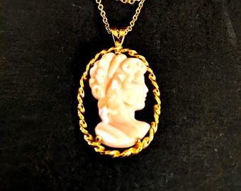 Camafeo de concha de 2,5 cm x 1,6 cm. Busto clásico de mujer, con montura y cadena doradas. N.º de inventario 0981Q