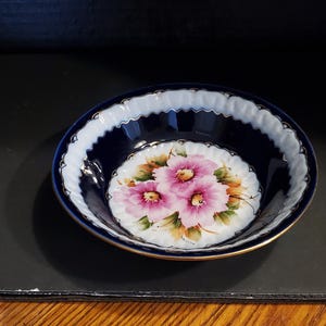 Cuenco rumano Iris de Cluj Napoca, 1922, pintado a mano, de 14,5 cm. Azul cobalto y blanco, con flores rosas y ribete dorado. Sin daños, INV n.° 1642.