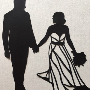 May include: Black silhouette of a couple holding hands. The woman is wearing a wedding dress with a bouquet of flowers. The man is wearing a suit.