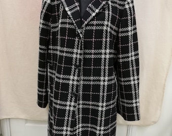 May include: A long black and white checked coat with a pink thread detail. The coat has a button fastening and a collar.