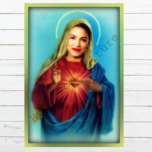 Puede incluir: Una impresión de arte digital de una mujer con cabello oscuro y lápiz labial rojo que lleva una túnica azul y roja con un corazón en el centro. La mujer está representada como la Virgen María.