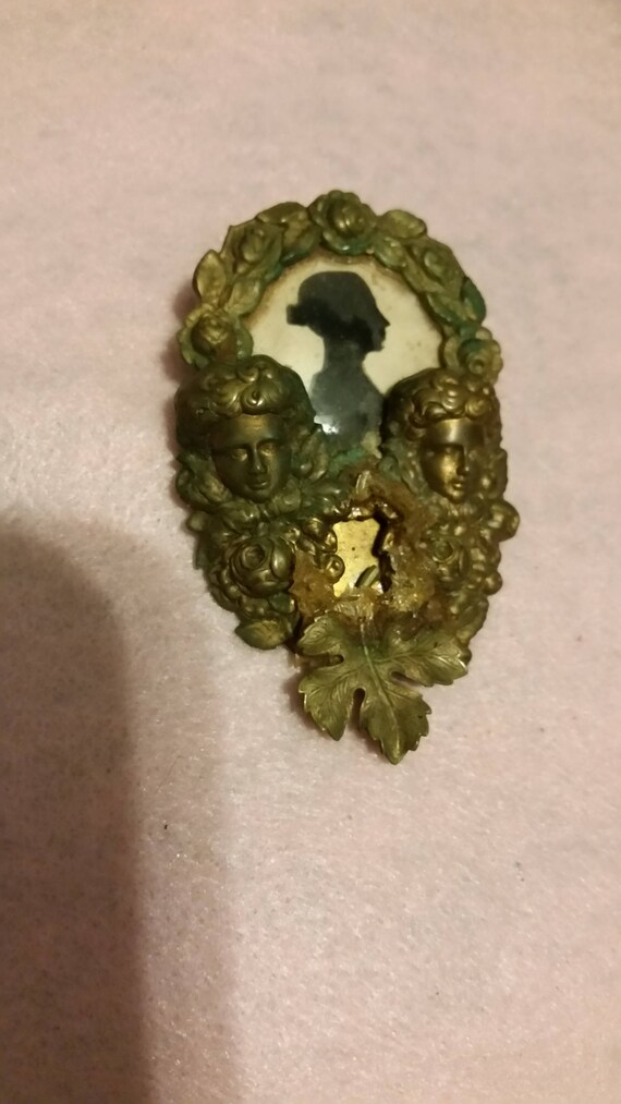 Odd brass with paper silhouette brooch