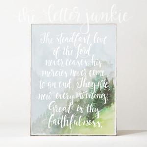 Op de afbeelding: Een aquarelprint met een citaat over de standvastige liefde van de Heer. Het citaat luidt: "De standvastige liefde van de Heer houdt nooit op, zijn barmhartigheid heeft geen einde. Ze zijn nieuw elke ochtend. Groot is uw trouw."