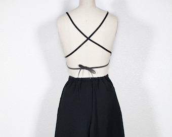 May include: Black wide-leg pants with a high waist and a relaxed fit. The pants are made of a smooth, lightweight fabric.