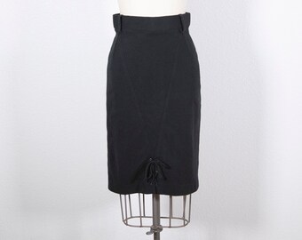 May include: A black pencil skirt with a lace-up detail at the front. The skirt is fitted and has a high waist.