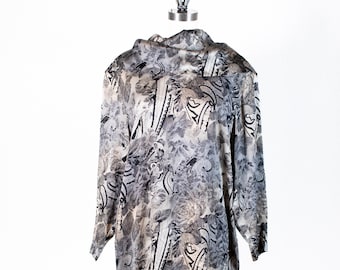 May include: A long-sleeved dress with a cowl neck and a black and white abstract print on a beige background.
