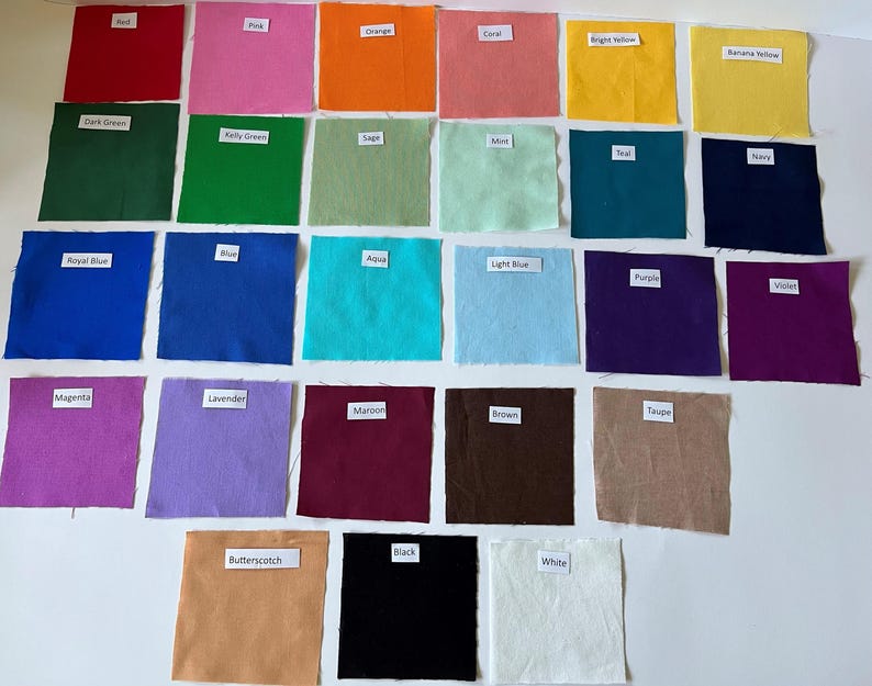 May include: A collection of twenty-three square fabric swatches arranged in rows, each featuring a small white label with text identifying the color. The colors include red, pink, orange, coral, bright yellow, banana yellow, dark green, kelly green, sage, mint, teal, navy, royal blue, blue, aqua, light blue, purple, violet, magenta, lavender, maroon, brown, taupe, butterscotch, black, and white.