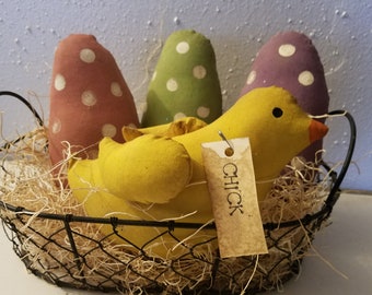 May include: A yellow chick with a brown tag that says "CHICK" is sitting in a wire basket with three polka dot eggs. The eggs are pink, green, and purple.