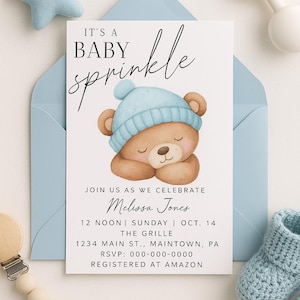 May include: A baby sprinkle invitation with a light blue envelope. The invitation features a sleeping teddy bear wearing a blue hat. Text includes "IT'S A BABY sprinkle" and event details.