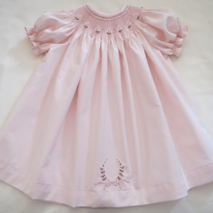女の子用の可愛らしいライトペールピンクのハンドスモックラウンドヨークビショップドレス。