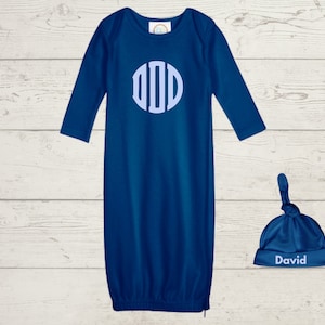 Puede incluir: Un babero azul para bebé con un monograma blanco y un gorro azul a juego con el nombre "David" bordado.