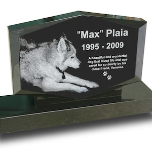 May include: Black granite pet memorial with a photo of a white dog and the inscription "Max" Plaia 1995-2009. The inscription continues with "A beautiful and wonderful dog that loved life and was cared for so dearly by his close friend, Venessa."