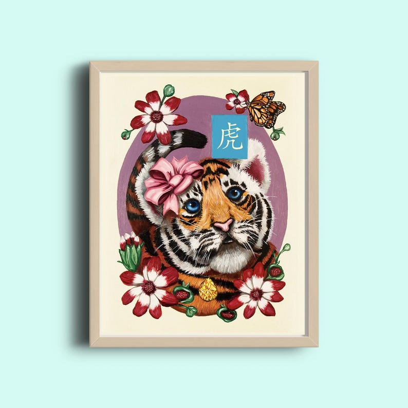 K&ouml;nnte beinhalten: Eine gerahmte Illustration eines Tigerjungen mit einer rosa Schleife. Der Tiger ist von roten Blumen und einem Schmetterling umgeben. Das chinesische Schriftzeichen f&uuml;r "Tiger" ist in Blau auf einem wei&szlig;en Quadrat geschrieben.