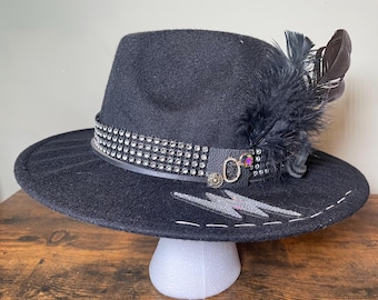 Chapeau noir personnalisé, strass et plumes, écusson éclair