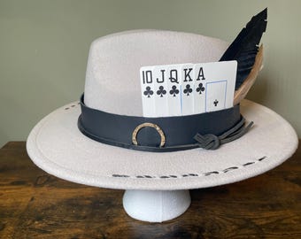 Chapeau marron clair personnalisé avec bracelet en cuir, plumes et cartes du House of Clubs