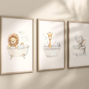May include: Three framed watercolor prints featuring adorable animals in bathtubs. A lion, giraffe, and elephant are depicted in vintage-style tubs with bubbles. The prints have a soft, pastel color palette and are framed in light wood.