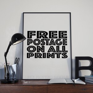 以下が含まれることがあります： 白黒のポスターに「FREE POSTAGE ON ALL PRINTS」というテキストが太字で縁取りされた文字で書かれています。ポスターは黒い額縁に収められ、白い壁に掛けられています。