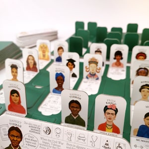 Who's She is a modern take on classic Guess Who board game. It consists of 2 boards, 28 biography cards, 2 legend strips & rulebook. In this green edition you will find herstories of Frida Kahlo, Malala Yousafzai or Marie Curie.