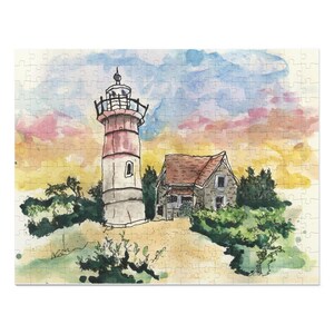 May include: A watercolor painting of a lighthouse and a small house with a red roof. The lighthouse is white with a red stripe and a black roof. The sky is a light blue with pink and yellow clouds. The scene is set against a backdrop of green trees and bushes.