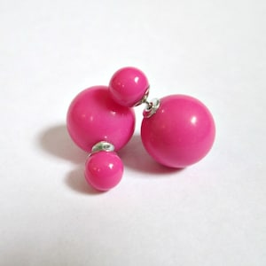 May include: A pair of pink double-sided earrings with a smaller pink ball on the bottom of each earring.