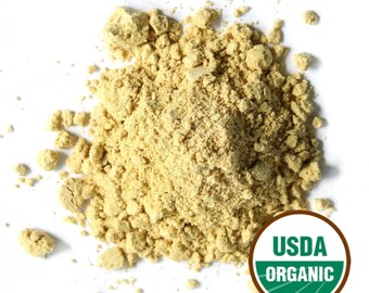 May include: A pile of light yellow-brown powder, possibly a spice or herb, sits against a white background. The USDA Organic seal is visible in the lower right corner, indicating the product's organic certification. The powder appears finely ground and textured.