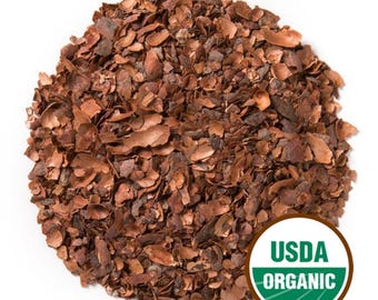 May include: A pile of brown cocoa nibs, with a variety of shapes and sizes, fills the frame. The image includes a USDA Organic seal in the lower right corner, indicating the product's certification.