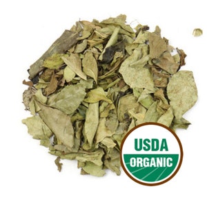 May include: A pile of dried, light green leaves, possibly for tea or herbal use, against a white background. A circular USDA ORGANIC label is visible in the lower right corner. The leaves have a natural, organic appearance.