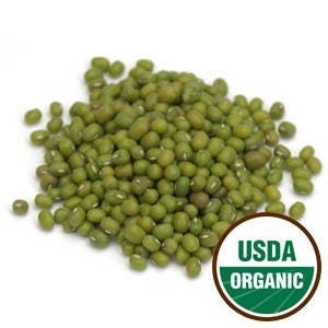 May include: A close-up view of a pile of green mung beans. The beans are small and round, and they have a slightly wrinkled surface. The beans are USDA Organic.