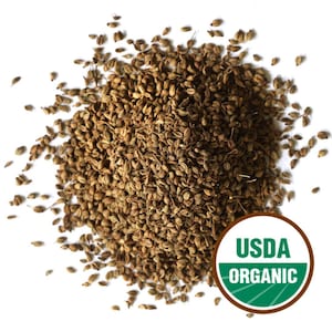 May include: A pile of brown anise seeds, with a USDA Organic seal in the lower right corner. The seeds are small, oval-shaped, and have a slightly textured surface. The seeds are a light brown color.